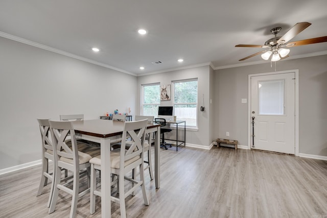 dining room featuring ornamental molding, light wood-style flooring, and baseboards