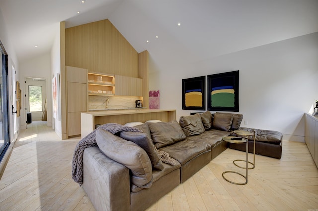 living room featuring high vaulted ceiling and light wood-style floors