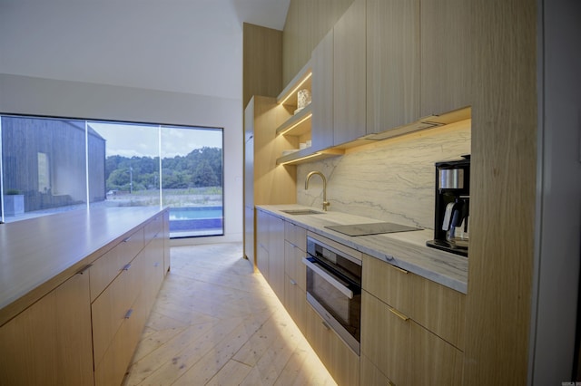 kitchen featuring black electric stovetop, a sink, stainless steel oven, open shelves, and modern cabinets