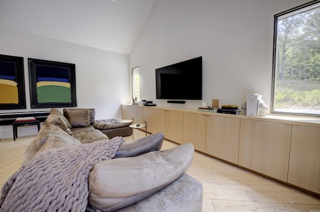 living room featuring light wood-style flooring and high vaulted ceiling