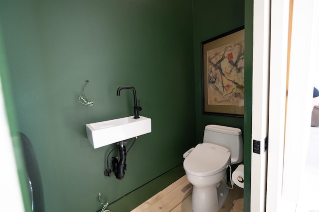 bathroom with wood finished floors, a sink, and toilet