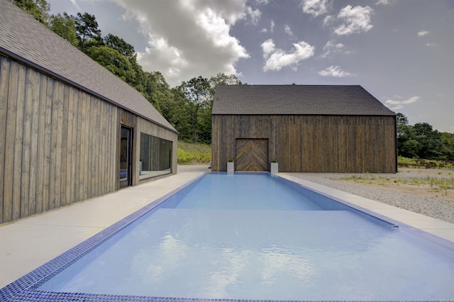 view of swimming pool with an outbuilding and a barn