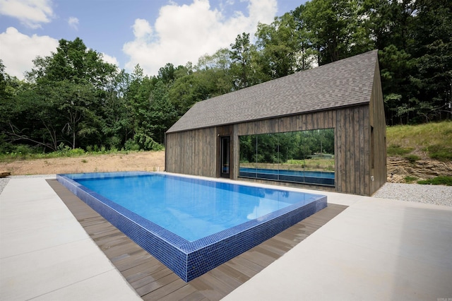 pool featuring a patio area and an outdoor structure