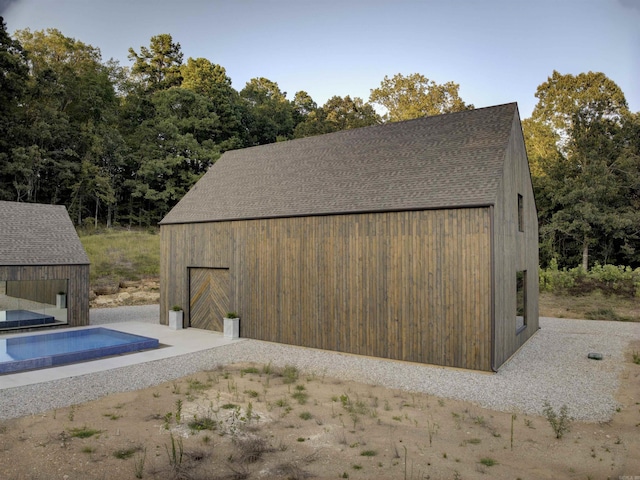 exterior space featuring an outdoor pool and an outdoor structure