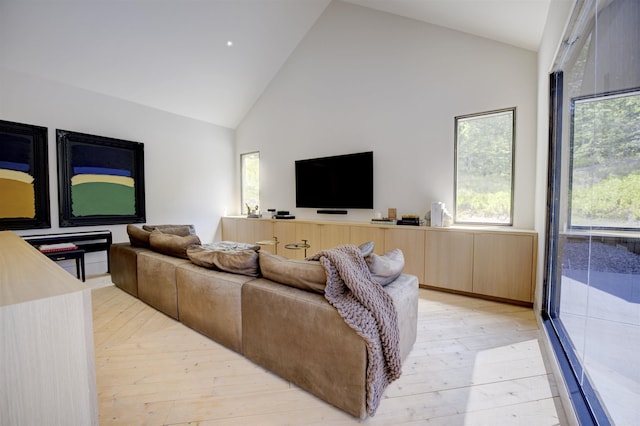 living room with light wood-style floors and high vaulted ceiling