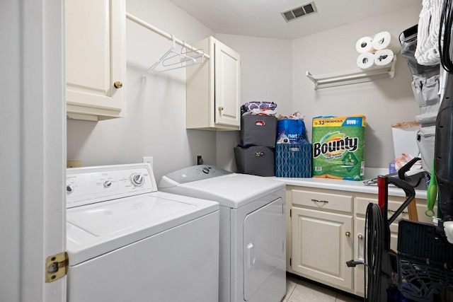 clothes washing area with washing machine and dryer, visible vents, cabinet space, and light tile patterned flooring