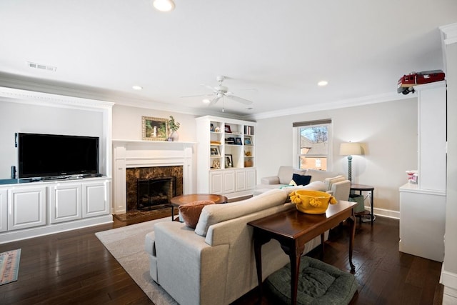 living area featuring dark wood finished floors, crown molding, a fireplace, recessed lighting, and visible vents