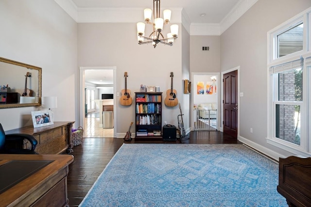 entrance foyer with a chandelier, a towering ceiling, baseboards, ornamental molding, and dark wood-style floors