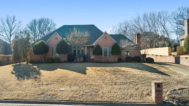 view of front of house featuring brick siding and fence