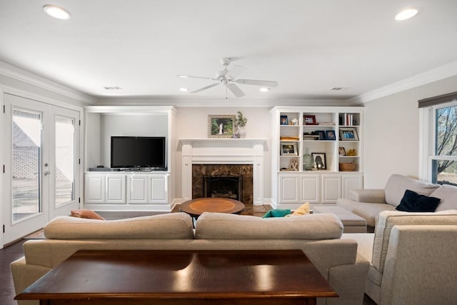 living room with ornamental molding, a high end fireplace, recessed lighting, and wood finished floors