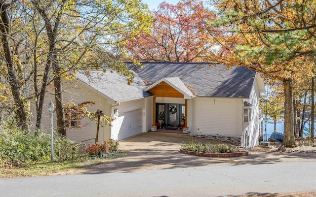 view of front facade featuring a garage, aphalt driveway, and a shingled roof