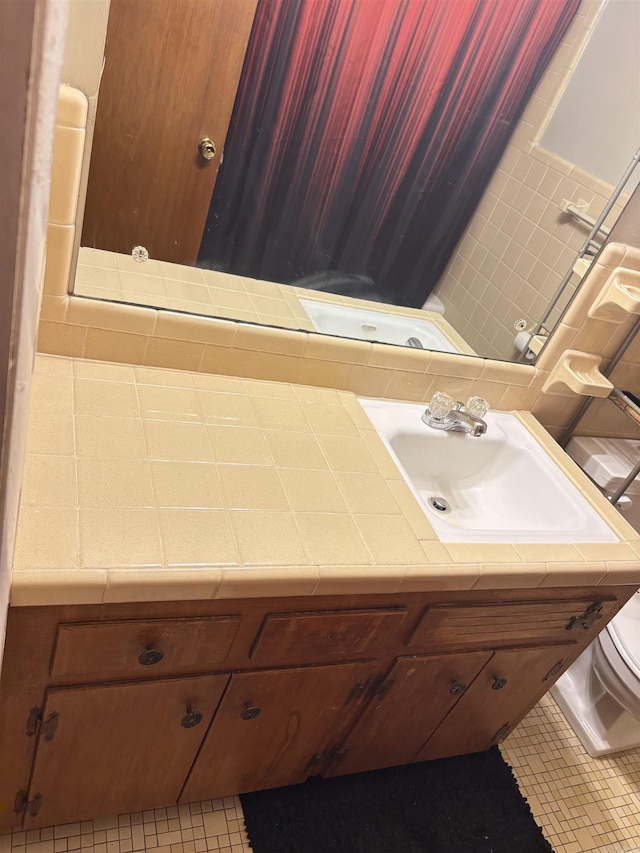 bathroom with toilet, tile patterned flooring, and vanity