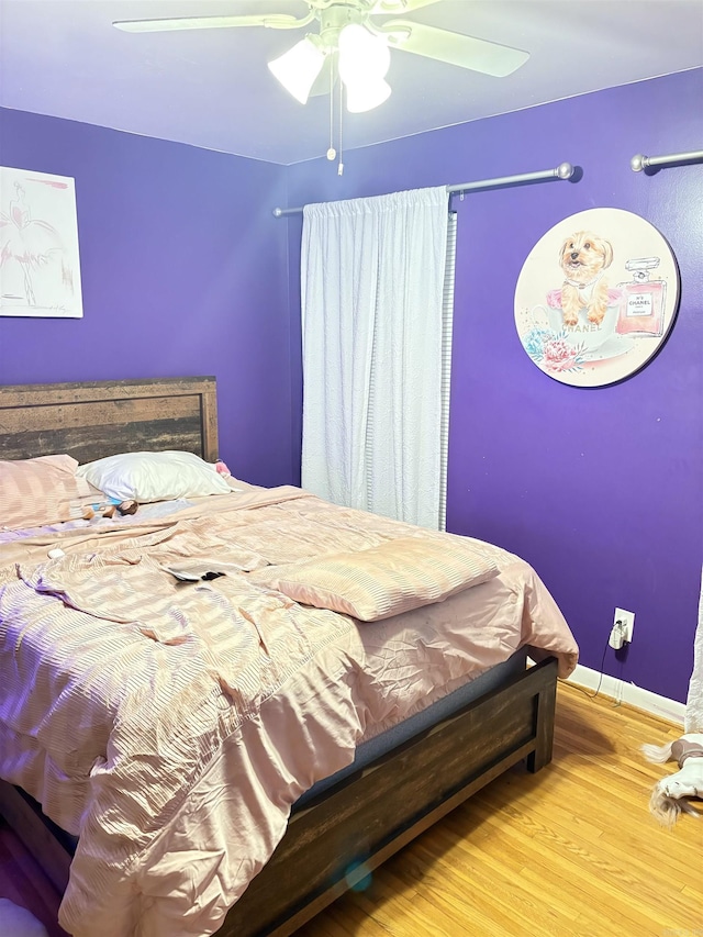 bedroom featuring ceiling fan, wood finished floors, and baseboards