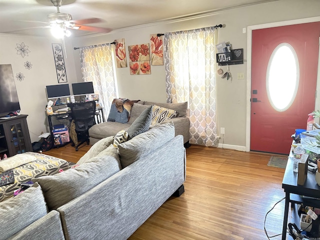 living area featuring ceiling fan, baseboards, and wood finished floors