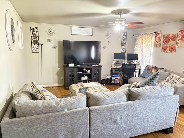 living room featuring baseboards, a ceiling fan, and wood finished floors