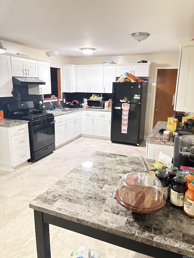 kitchen with black appliances, tasteful backsplash, white cabinets, and under cabinet range hood