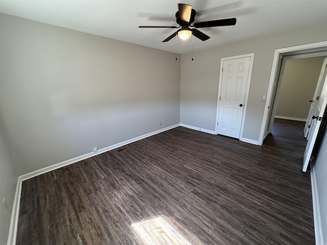 unfurnished bedroom featuring dark wood finished floors, baseboards, and ceiling fan