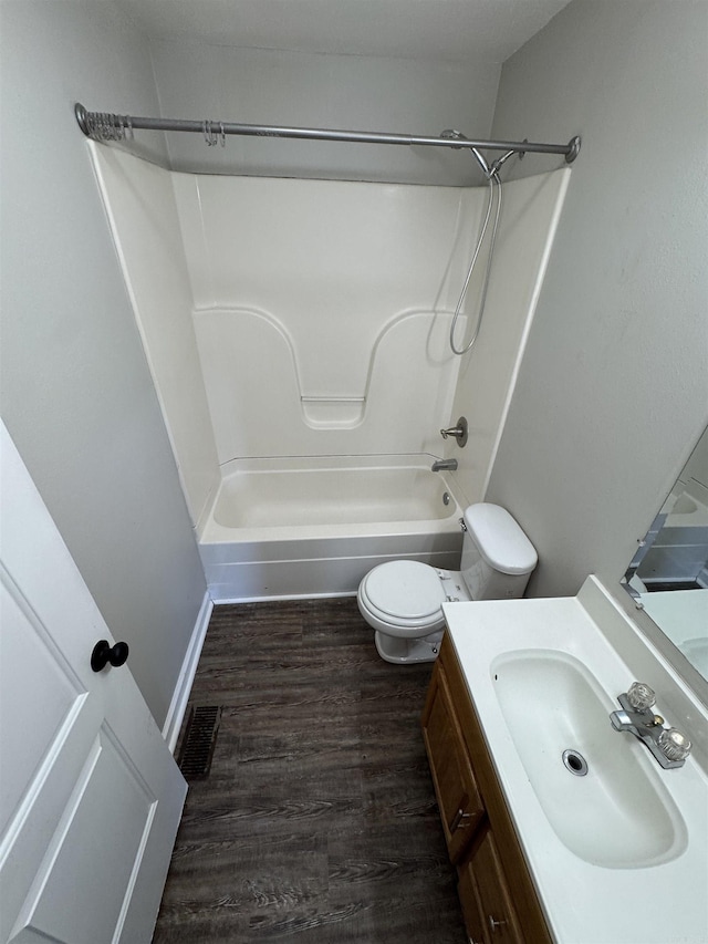 full bath with visible vents, toilet, wood finished floors, tub / shower combination, and vanity