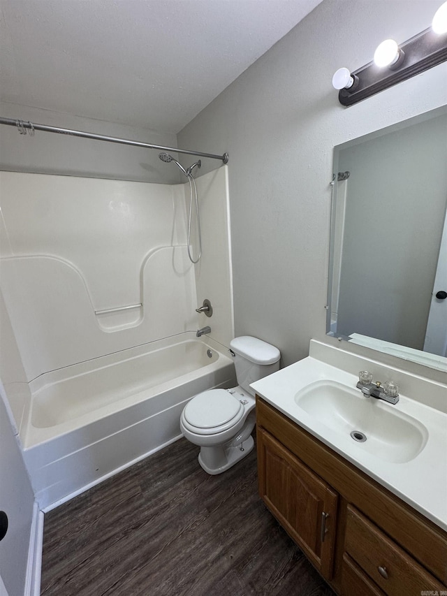 bathroom with vanity,  shower combination, wood finished floors, and toilet