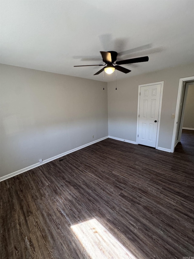 unfurnished bedroom featuring dark wood-style flooring, visible vents, ceiling fan, and baseboards