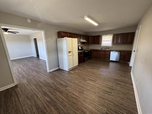 kitchen featuring under cabinet range hood, appliances with stainless steel finishes, dark wood finished floors, and a sink