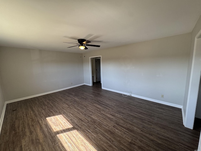 empty room featuring ceiling fan, baseboards, and dark wood-style flooring