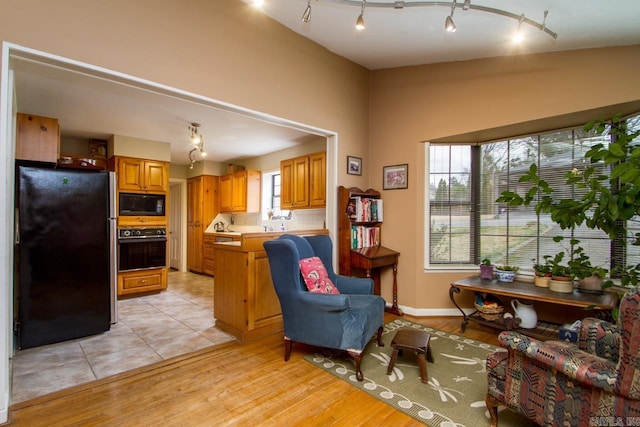 interior space with rail lighting, light wood-style flooring, and baseboards