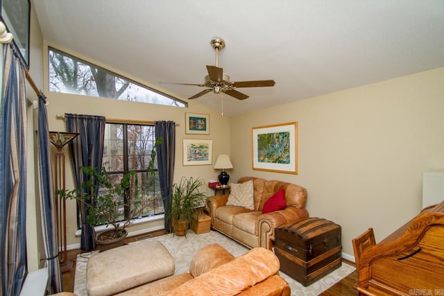 living room with lofted ceiling, visible vents, ceiling fan, and baseboards