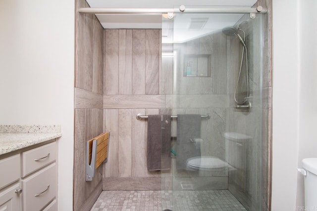 full bath featuring toilet, a stall shower, and vanity