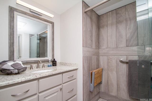 bathroom with a shower stall and vanity