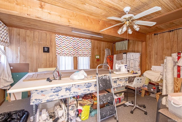 interior space featuring wood ceiling, wooden walls, a ceiling fan, and carpet flooring