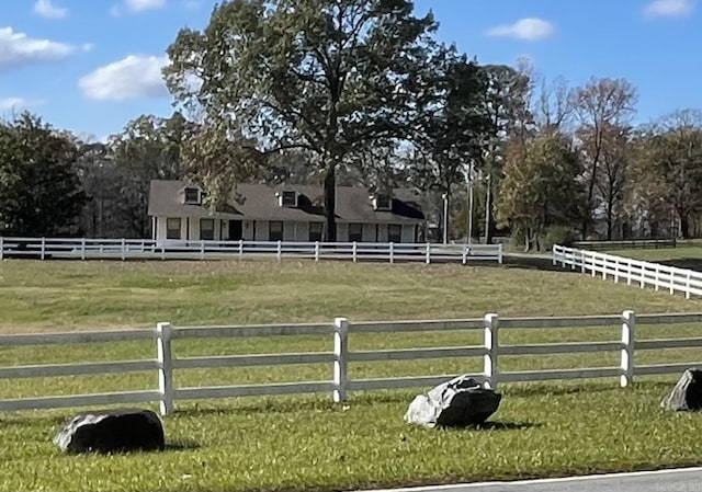 view of yard featuring a rural view, an enclosed area, and fence