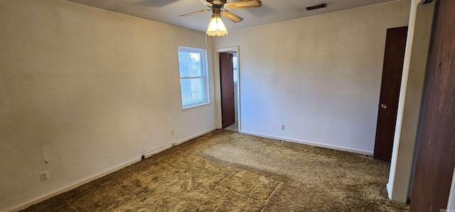 carpeted empty room featuring visible vents, ceiling fan, and baseboards