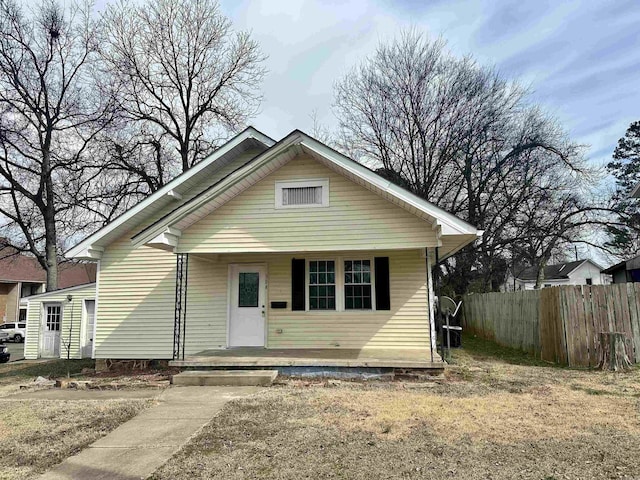 bungalow featuring covered porch and fence