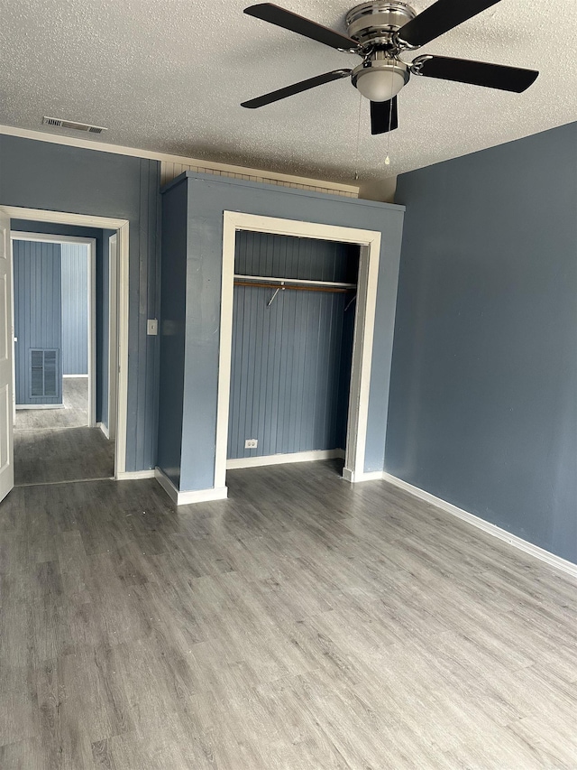 unfurnished bedroom featuring a closet, visible vents, and wood finished floors