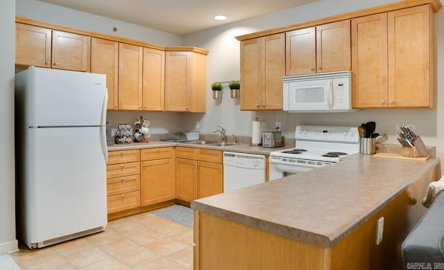 kitchen with white appliances, a peninsula, light countertops, a sink, and recessed lighting