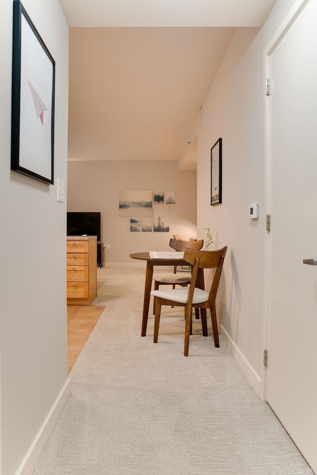 dining room with light carpet and baseboards