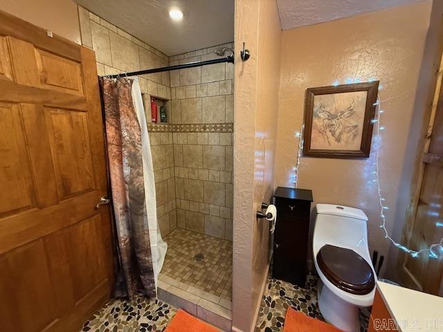 full bathroom with toilet and tiled shower