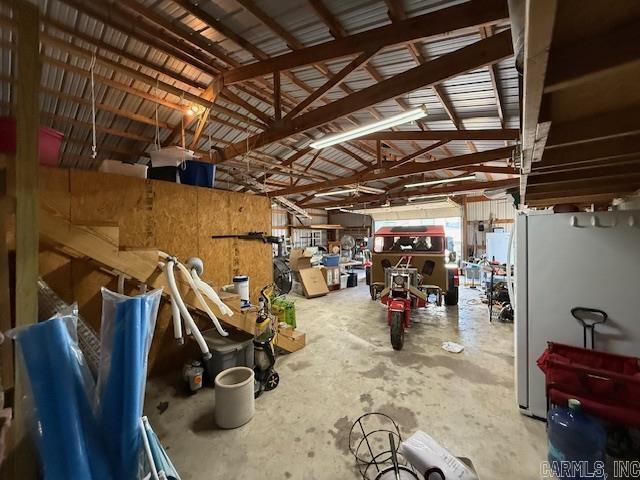 interior space with a garage, concrete flooring, and vaulted ceiling