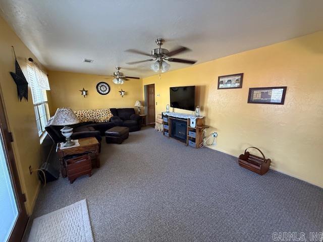 carpeted living area with visible vents and ceiling fan