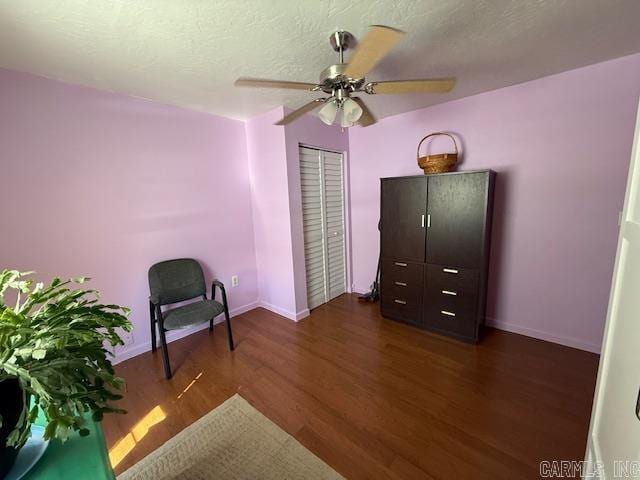 sitting room with baseboards, a textured ceiling, wood finished floors, and a ceiling fan