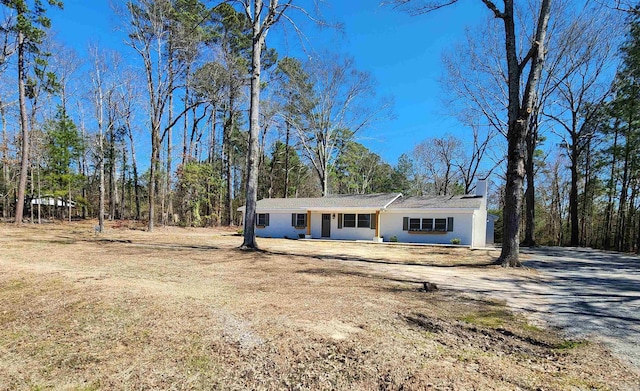 view of front of home featuring driveway and a chimney