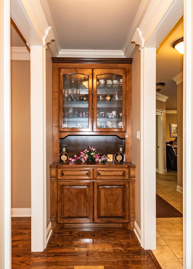 bar with baseboards, dark wood-type flooring, and crown molding