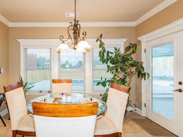 dining area with a notable chandelier, visible vents, baseboards, ornamental molding, and tile patterned floors