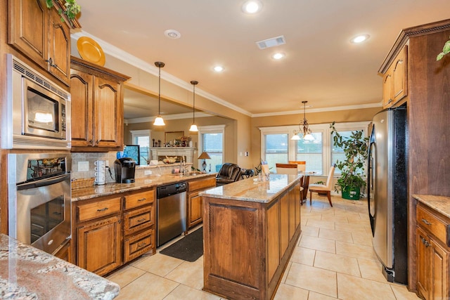 kitchen with visible vents, appliances with stainless steel finishes, brown cabinetry, and a center island