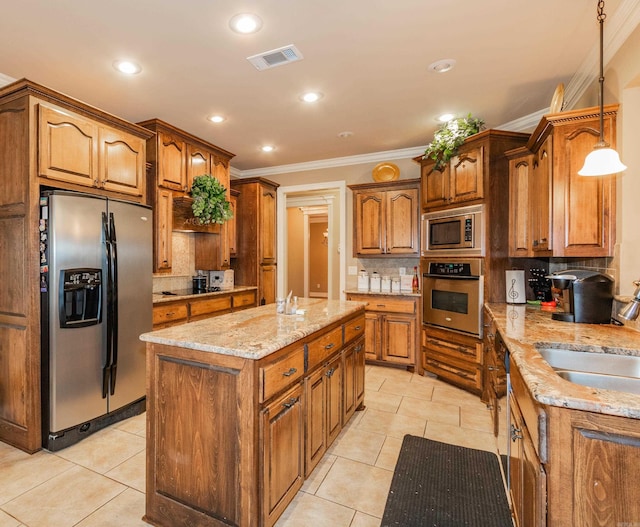 kitchen with light tile patterned floors, visible vents, brown cabinets, stainless steel appliances, and a sink