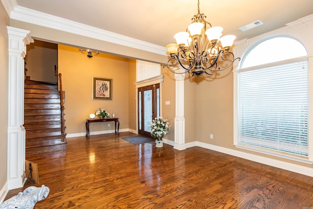 interior space with visible vents, ornamental molding, wood finished floors, baseboards, and stairs