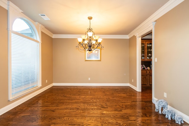 empty room featuring a chandelier, dark wood-style flooring, visible vents, and a healthy amount of sunlight