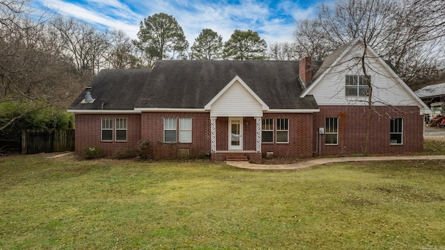 cape cod house with brick siding, a shingled roof, fence, and a front yard