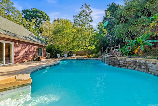 outdoor pool featuring a patio area and fence